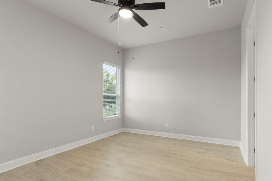 Empty room featuring light wood finished floors and ceiling fan
