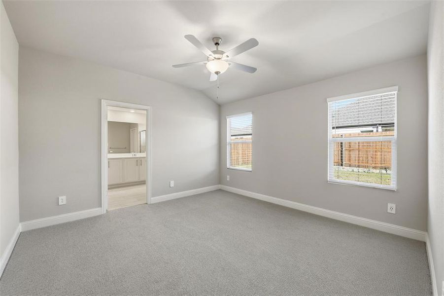 Spare room with light carpet, a ceiling fan, and lofted ceiling