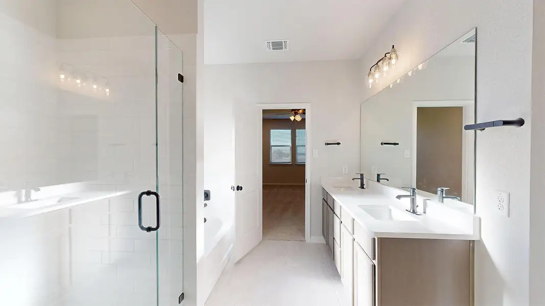 Full bathroom with double vanity, a bath, and a stall shower