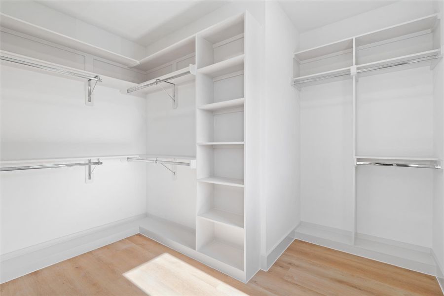 Custom built-ins & ample shelving define this walk-in closet, a refined space for storing wardrobe essentials & accessories. Custom built-ins & ample shelving define this walk-in closet, a refined space for storing wardrobe essentials & accessories.
