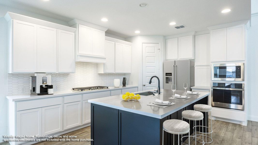 Kitchen featuring light wood-type flooring, appliances with stainless steel finishes, tasteful backsplash, an island with sink, and recessed lighting Kitchen featuring light wood-type flooring, appliances with stainless steel finishes, tasteful backsplash, an island with sink, and recessed lighting