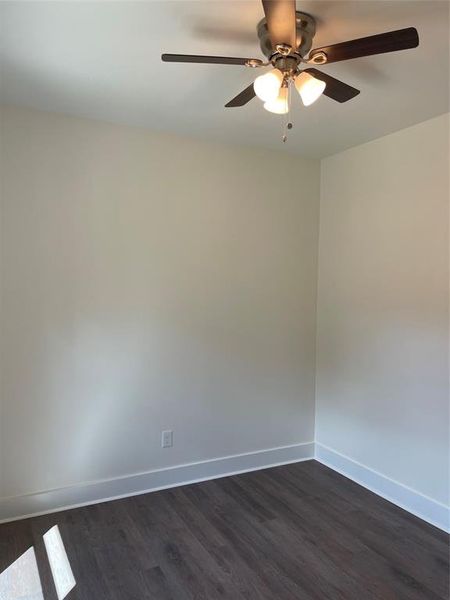 Unfurnished room with dark hardwood / wood-style flooring and ceiling fan