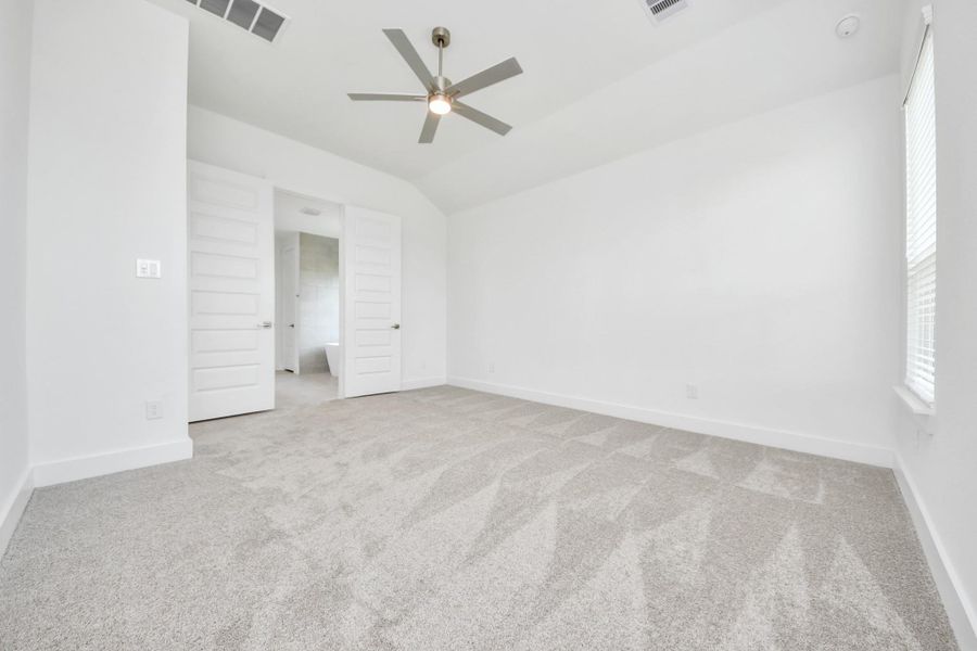 Escape and relax in the exquisite primary suite, a haven to unwind after a long day. The spacious room, located on first floor, boasts plush carpeting, soothing paint tones, high ceilings, and expansive windows adorned with privacy blinds.