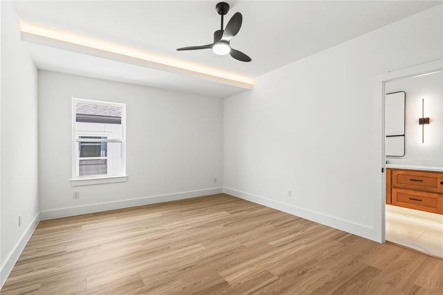 Empty room with light wood finished floors and a ceiling fan