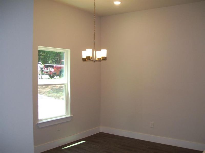 Unfurnished room featuring a chandelier, dark wood finished floors, plenty of natural light, and recessed lighting Unfurnished room featuring a chandelier, dark wood finished floors, plenty of natural light, and recessed lighting