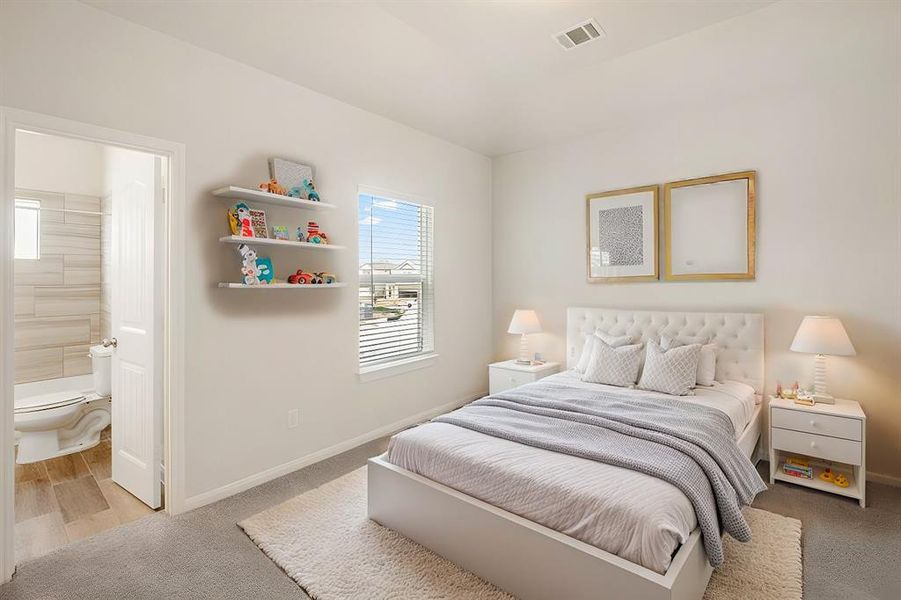 A beautifully designed bedroom with convenient access to a modern ensuite bath. Enjoy privacy and comfort in this thoughtfully crafted space, featuring plush carpeting and sunlit windows for a cheerful atmosphere.