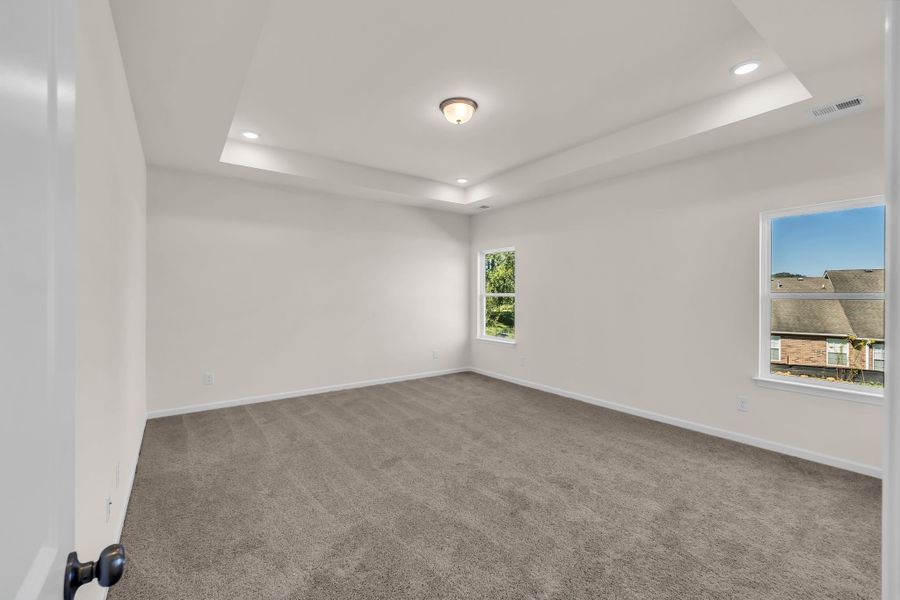 Primary suite with elegant tray ceiling. Primary suite with elegant tray ceiling.