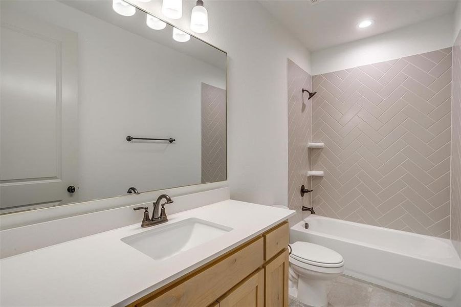 Full bath featuring washtub / shower combination, toilet, and vanity