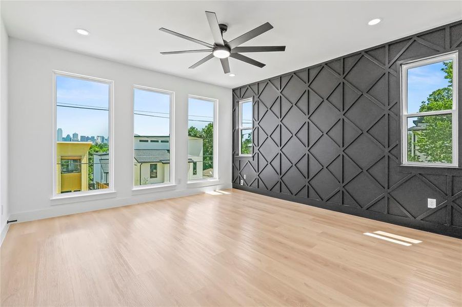 Empty room featuring an accent wall, light wood-type flooring, ceiling fan, healthy amount of natural light, and recessed lighting