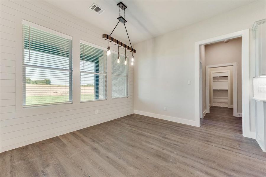 Unfurnished dining area with light hardwood / wood-style flooring and wooden walls