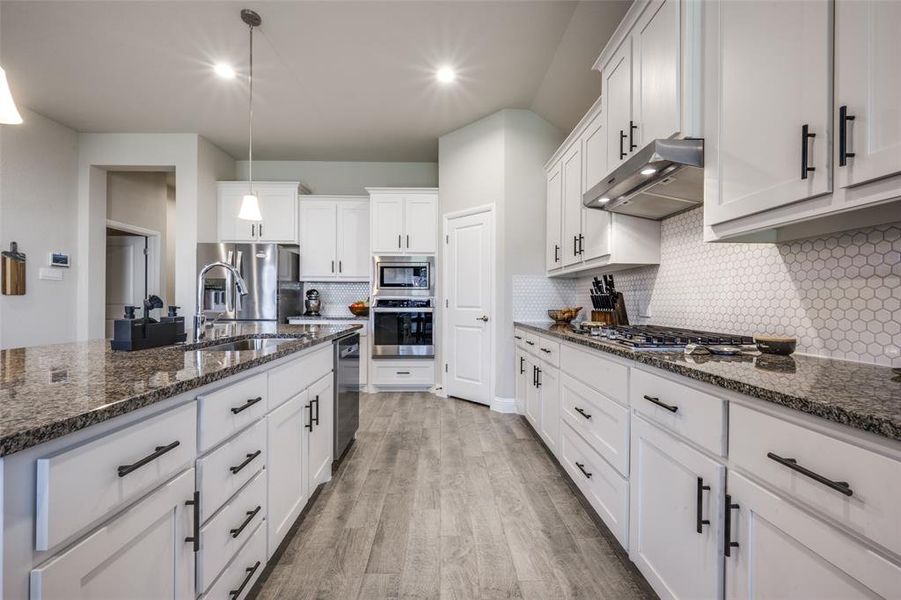 Beautiful kitchen with granite countertops, stainless steel appliances, gas cooktop, large walk in pantry, pennant lighting and plenty of cabinets