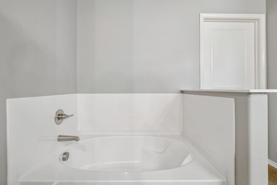 Unwind in the pristine white soaking tub, an ideal spot for relaxation and rejuvenation. Unwind in the pristine white soaking tub, an ideal spot for relaxation and rejuvenation.