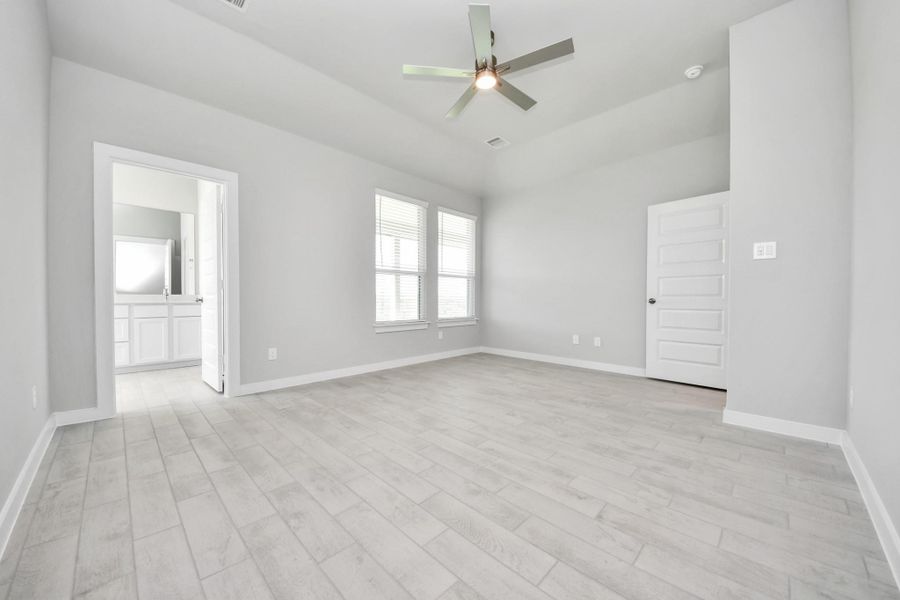 Another perspective unveils a comprehensive view of the serenity and comfort this primary suite offers. Sample photo of completed home with similar floor plan. Actual colors and selections may vary.