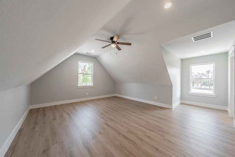 Additional living space with ceiling fan, vaulted ceiling, and light hardwood / wood-style floors