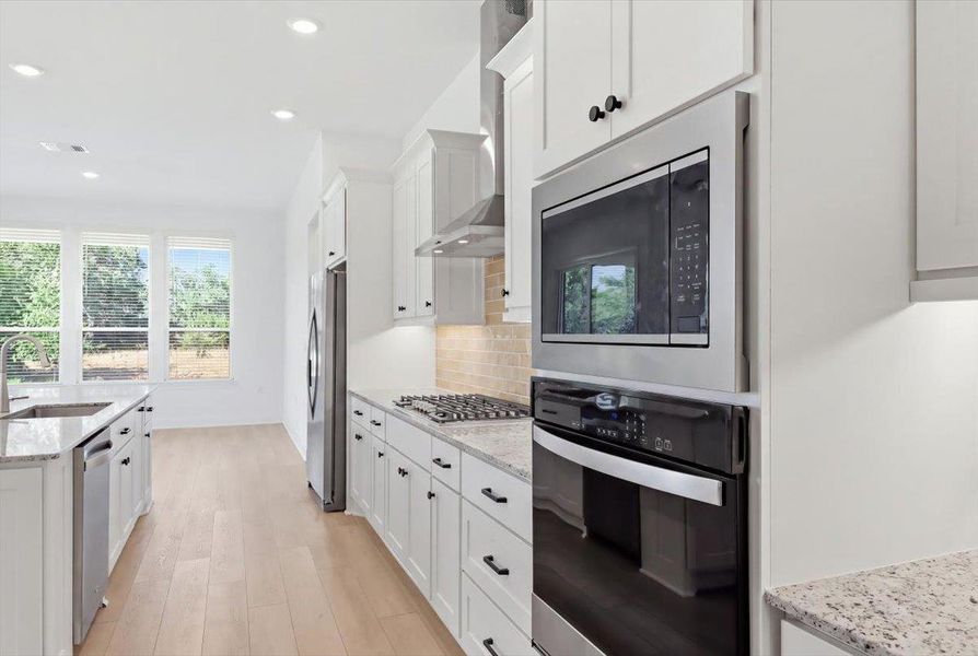 Culinary adventures await in this naturally illuminated kitchen with contemporary finishes and ample space. Culinary adventures await in this naturally illuminated kitchen with contemporary finishes and ample space.