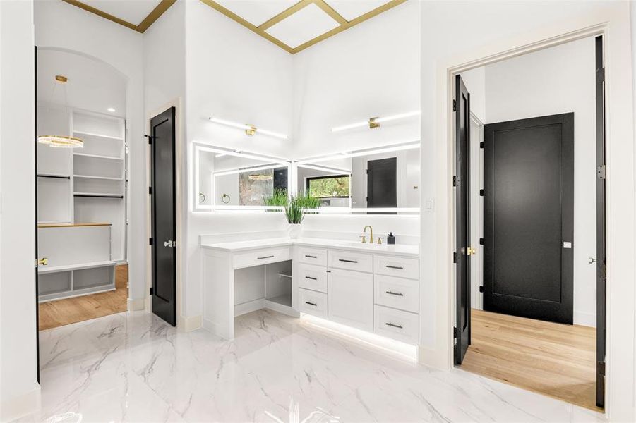 Spacious bathroom featuring white marble-look tile flooring and a dual vanity with white cabinetry