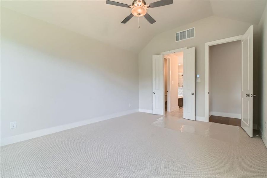 Unfurnished bedroom with lofted ceiling, carpet, and a ceiling fan Unfurnished bedroom with lofted ceiling, carpet, and a ceiling fan