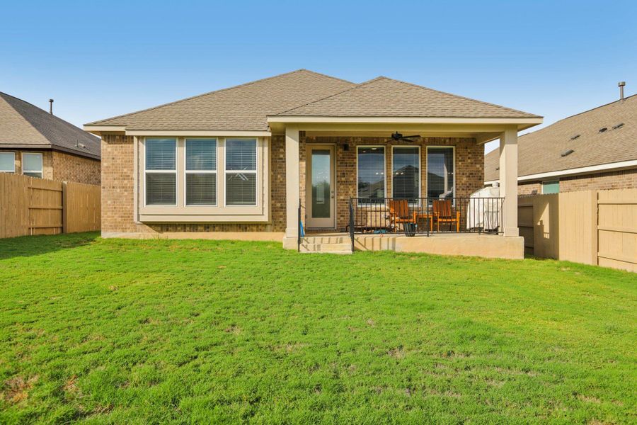Rear view of property featuring a fenced backyard, brick siding, a ceiling fan, and roof with shingles Rear view of property featuring a fenced backyard, brick siding, a ceiling fan, and roof with shingles