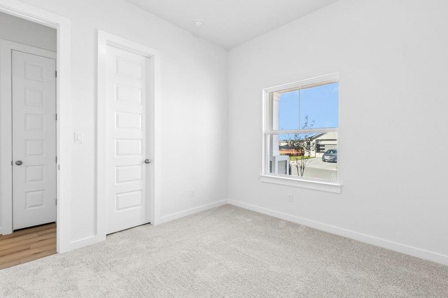 Spare room with light colored carpet and baseboards