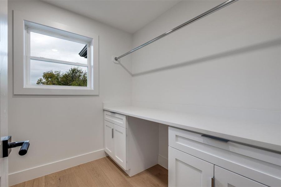 Washroom with light wood-type flooring and baseboards