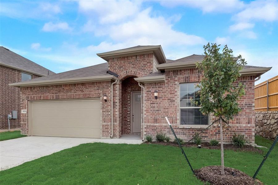 View of front of home featuring a garage and a front yard