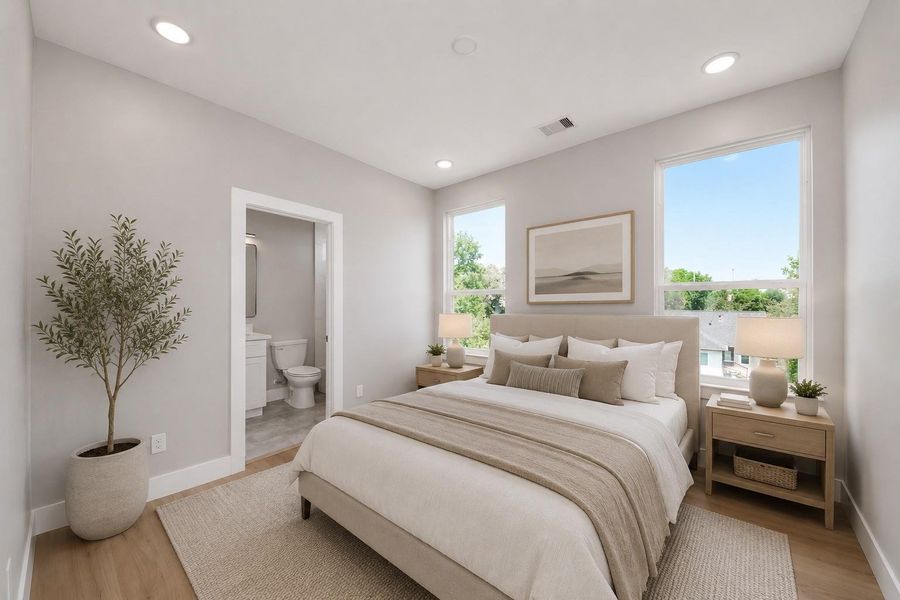 Comfortable guest bedroom featuring abundant natural light, modern finishes, & convenient access to a private ensuite bath.