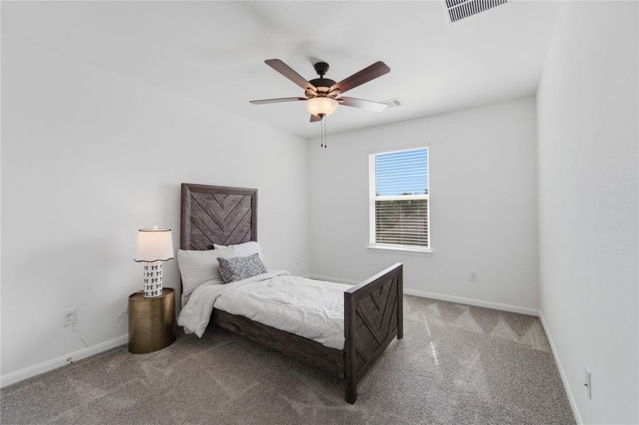 A well-lit room offers comfort with soft carpet and a convenient ceiling fan for airflow. A well-lit room offers comfort with soft carpet and a convenient ceiling fan for airflow.