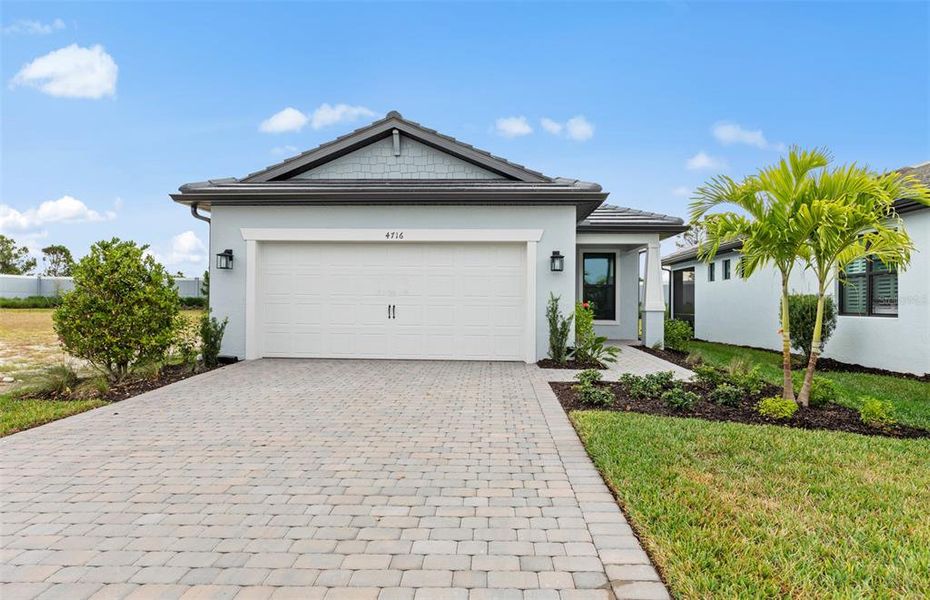 Front exterior of a new home in Arbor Oaks, North Port, FL, highlighting curb appeal (Image 2). Front exterior of a new home in Arbor Oaks, North Port, FL, highlighting curb appeal (Image 2).
