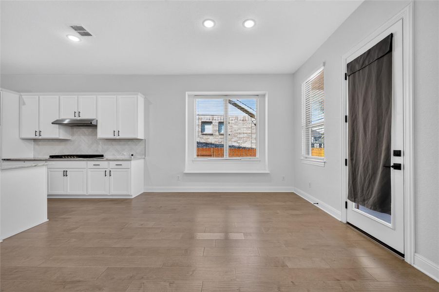 Hardwood floors and recessed lighting enhance this bright dining space adjacent to the kitchen. Hardwood floors and recessed lighting enhance this bright dining space adjacent to the kitchen.