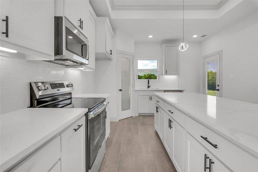 Kitchen featuring stainless steel appliances, backsplash, healthy amount of natural light, light countertops, and recessed lighting Kitchen featuring stainless steel appliances, backsplash, healthy amount of natural light, light countertops, and recessed lighting