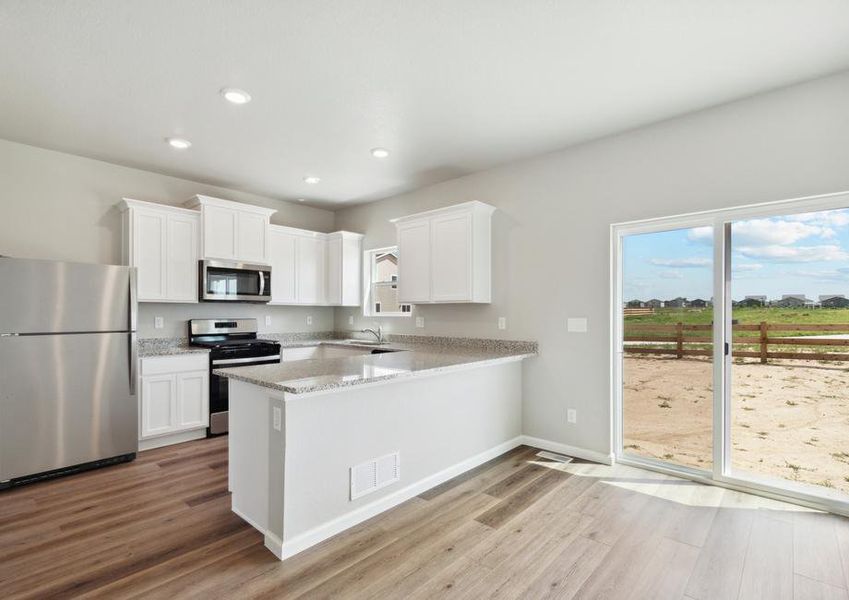 The kitchen of the Laramie has beautiful white wood cabinets.