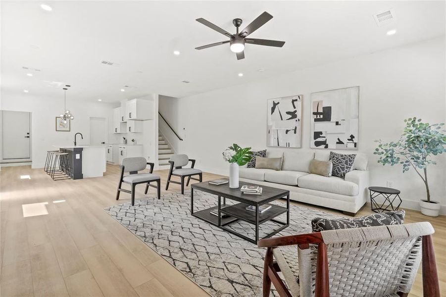 Living area with stairway, recessed lighting, a ceiling fan, and light wood finished floors Living area with stairway, recessed lighting, a ceiling fan, and light wood finished floors