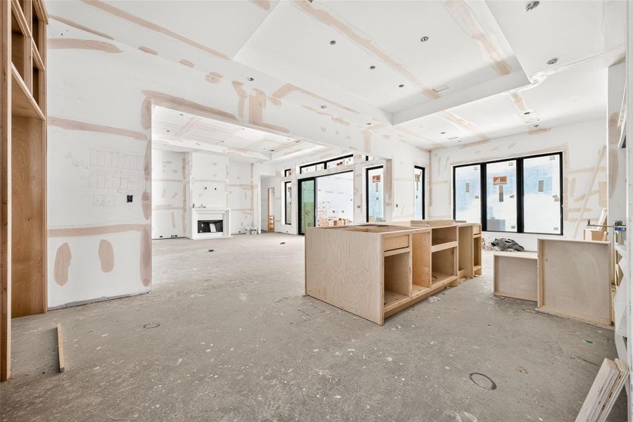 View of the kitchen opening to the family room with breakfast nook overlooking the covered patio.