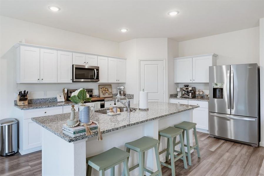 Kitchen featuring white shaker-style cabinetry, granite countertops, and stainless steel appliances