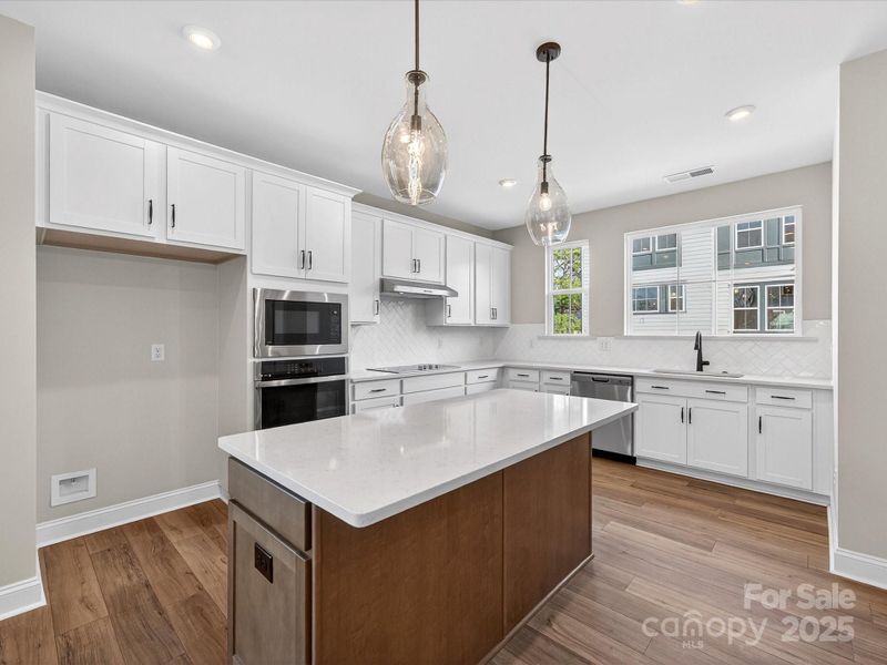 Gourmet Kitchen Layout with Designer Pendant Lighting.