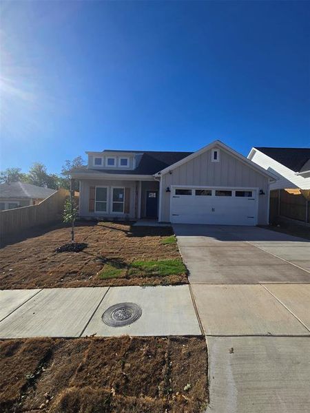 View of front of property featuring board and batten siding, concrete driveway, a porch, and a garage