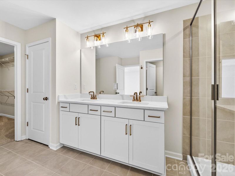 Dual vanity in primary bath feature quartz countertops, soft close drawers and cabinet doors. Tiled shower with bench- separate toilet and large walk-in closet Dual vanity in primary bath feature quartz countertops, soft close drawers and cabinet doors. Tiled shower with bench- separate toilet and large walk-in closet