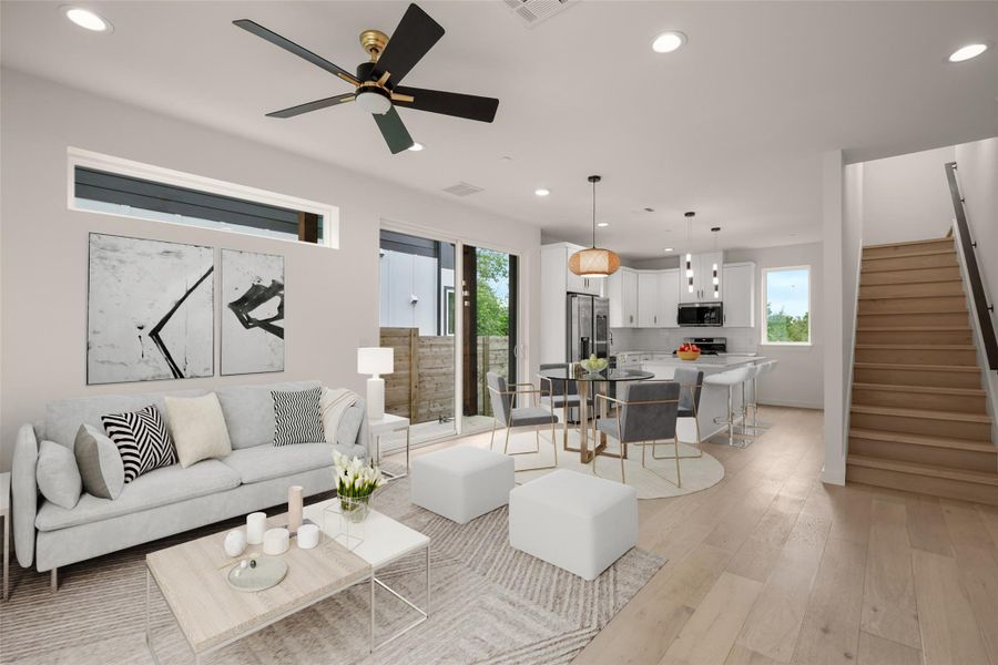 Living area featuring light wood finished floors, recessed lighting, and a ceiling fan -Virtually Staged