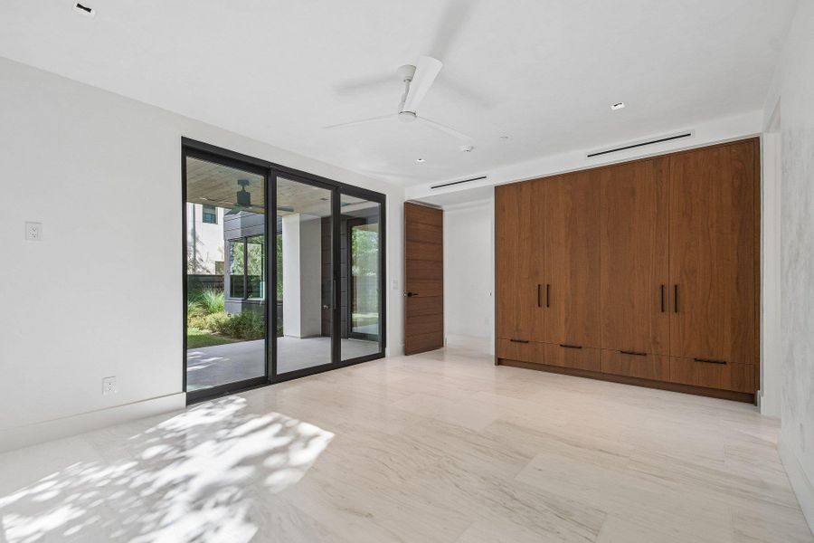 Floor-to-ceiling sliding glass doors open directly to a covered patio from this modern interior. Floor-to-ceiling sliding glass doors open directly to a covered patio from this modern interior.