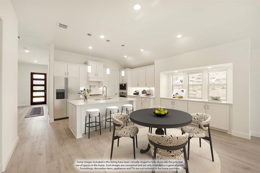 Open kitchen and dining area with white cabinets, large island, pendant lights, and hardwood floors