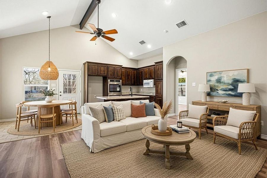 Living area with dark wood finished floors, a ceiling fan, and arched walkways "Virtually staged to help you visualize the potential of this space."