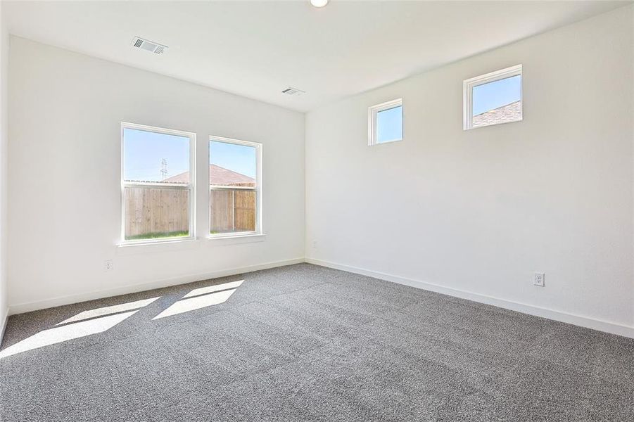 Empty room featuring plenty of natural light and carpet