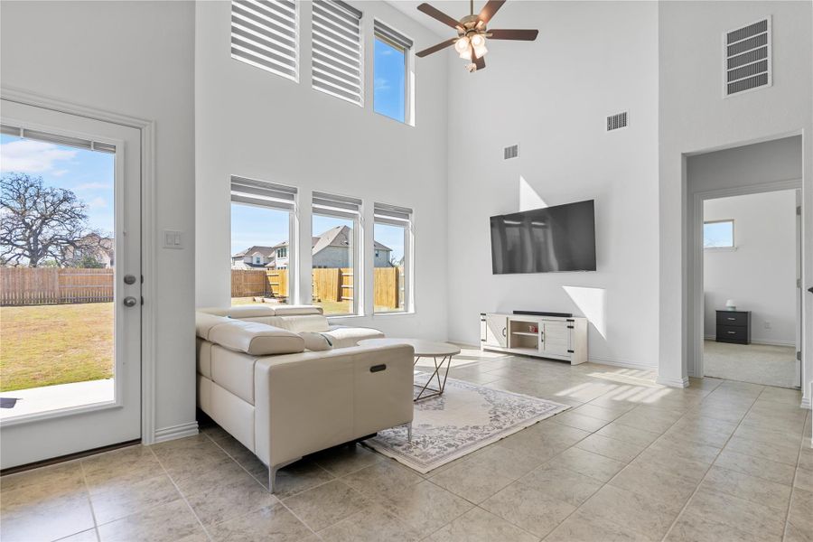 A lofty living area presents generous natural illumination and backyard access through clear glass paneled doors. A lofty living area presents generous natural illumination and backyard access through clear glass paneled doors.