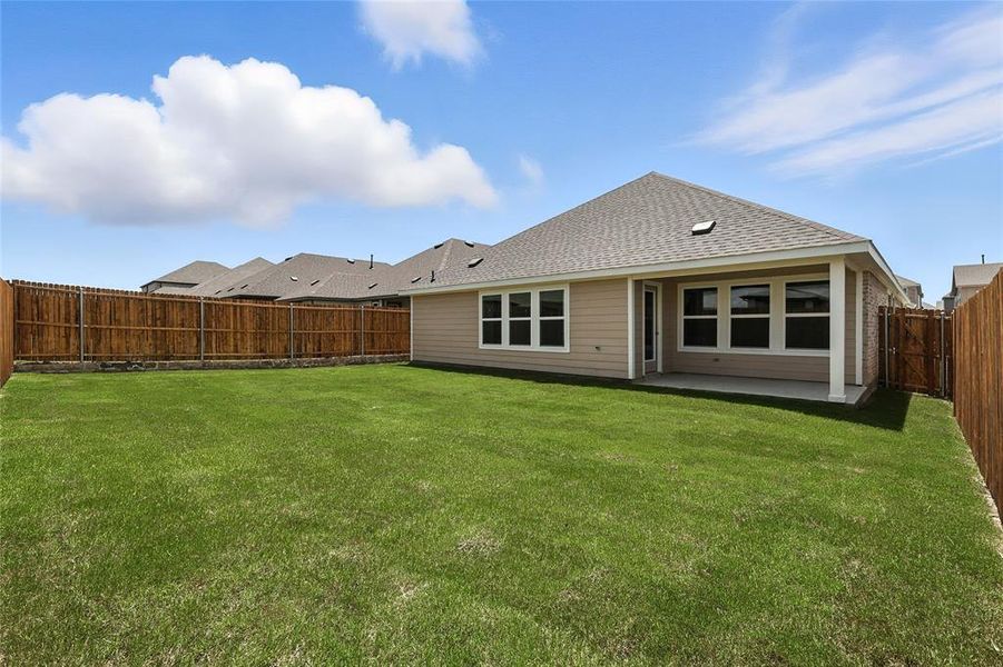 Back of property featuring roof with shingles, a fenced backyard, and a patio