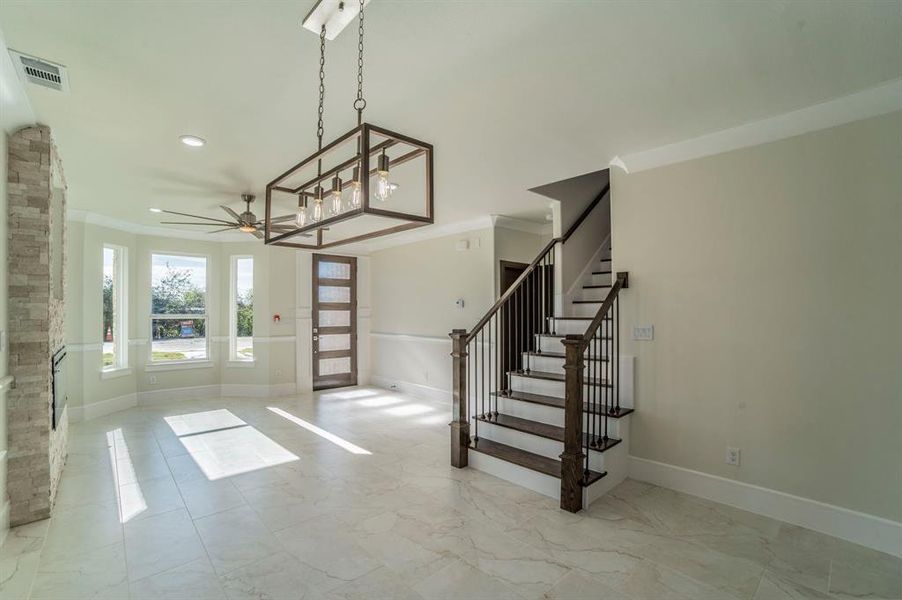 Entryway with ornamental molding, stairway, ceiling fan, recessed lighting, and light marble finish flooring Entryway with ornamental molding, stairway, ceiling fan, recessed lighting, and light marble finish flooring