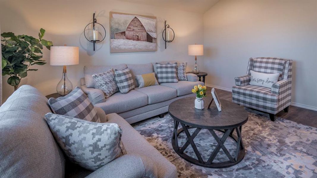 Spacious living area featuring light-toned walls, wood-finish flooring, and a decorative area rug