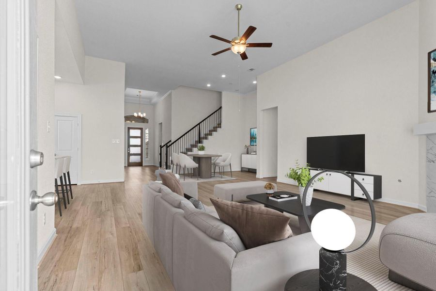 Open-concept family room with soaring ceilings, wood-look flooring, and a gas fireplace—perfect for gatherings and relaxation.  Upstairs you will discover the Guest Bedroom Upstairs and Full Bathroom!  What a fabulous floor plan! *Virtually Staged*