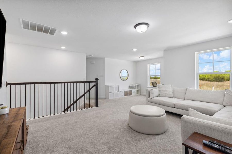 Carpeted living room with visible vents and recessed lighting Carpeted living room with visible vents and recessed lighting