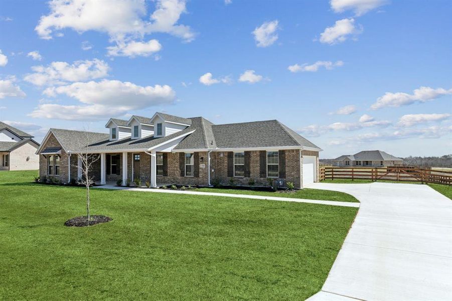 View of front of house featuring a front lawn, fence, concrete driveway, a shingled roof, and brick siding