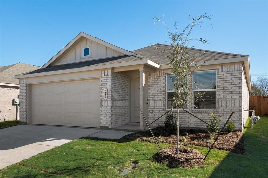 View of front of house featuring a front lawn and a garage